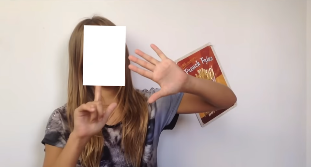 Screenshot von einem Video von Paula. Sie ist darauf zu sehen, wie sie 6 Finger hochhält. Wir haben ihr Gesicht zensiert.